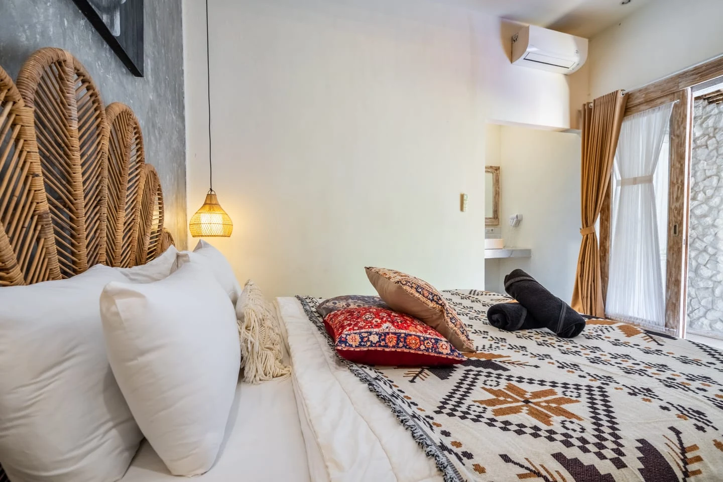 Bedroom with rattan headboard and patterned bed linen